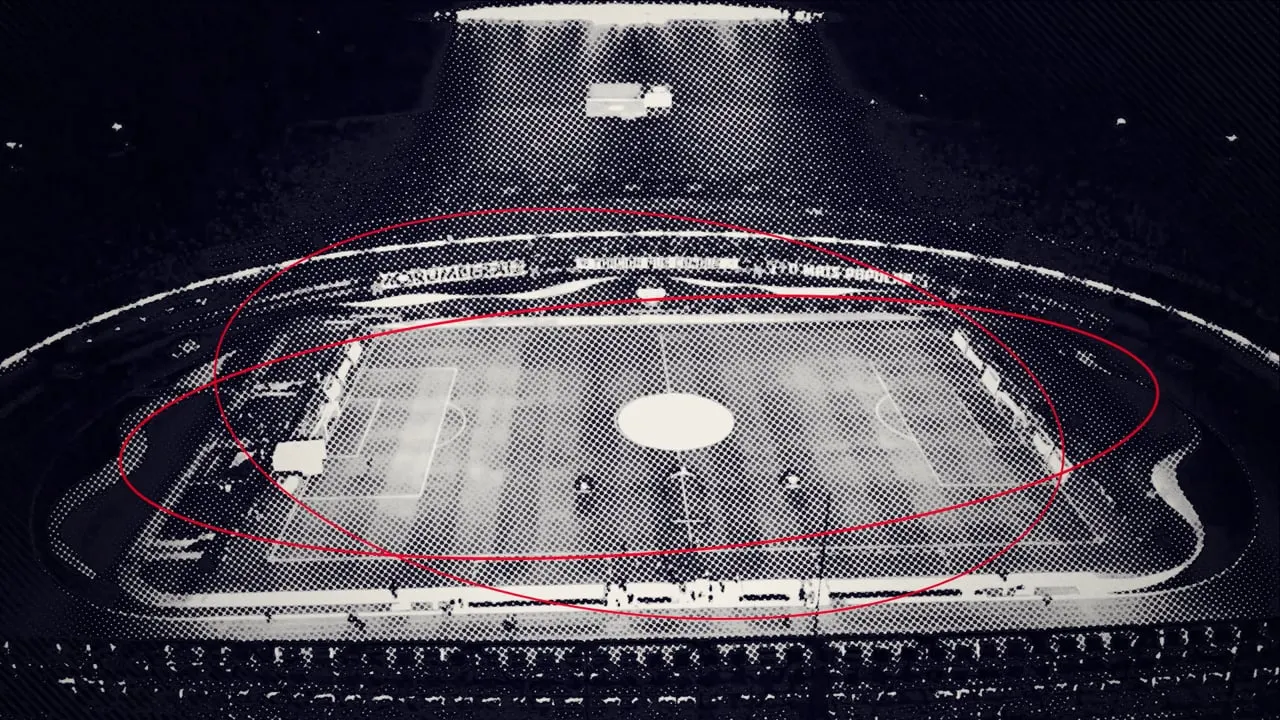 Um estádio de futebol visto de cima, à noite, impresso em retícula, com linhas vermelhas desenhadas em volta do campo.